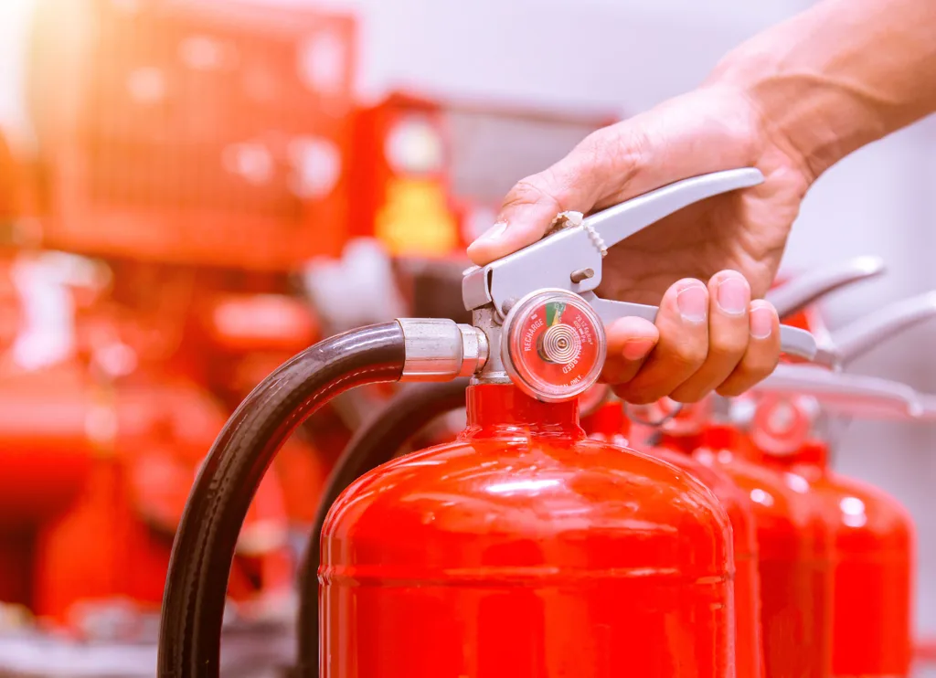 The 12 Hazards of Christmas - Essential Building Safety Tips for Commercial Premises this image shows an extinguisher being tested