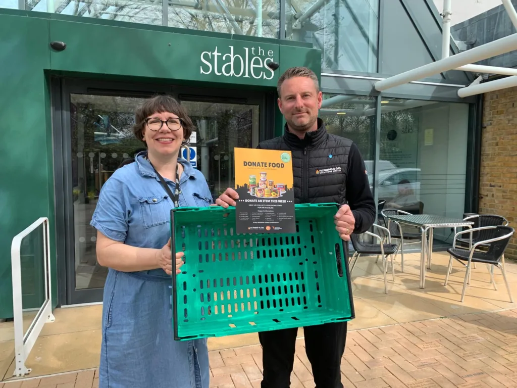 The Stables Milton Keynes staff receiving MK Food Bank donation crate outside venue entrance